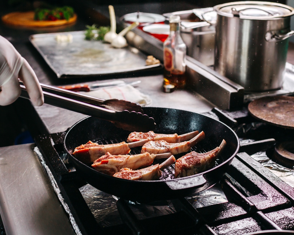 cook-frying-meat-ribs-inside-round-metal-pan-kitchen.jpg