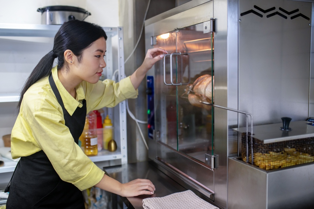 young-asian-woman-working-kitchen-regulating-ovens-temperature.jpg